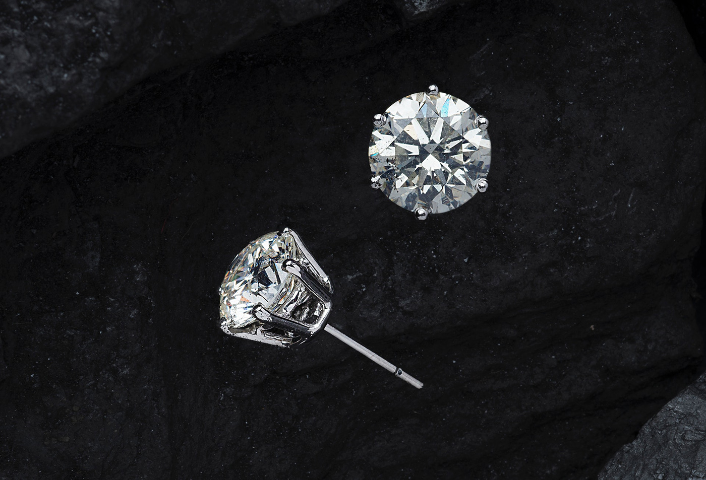 Diamond earrings on a black background.